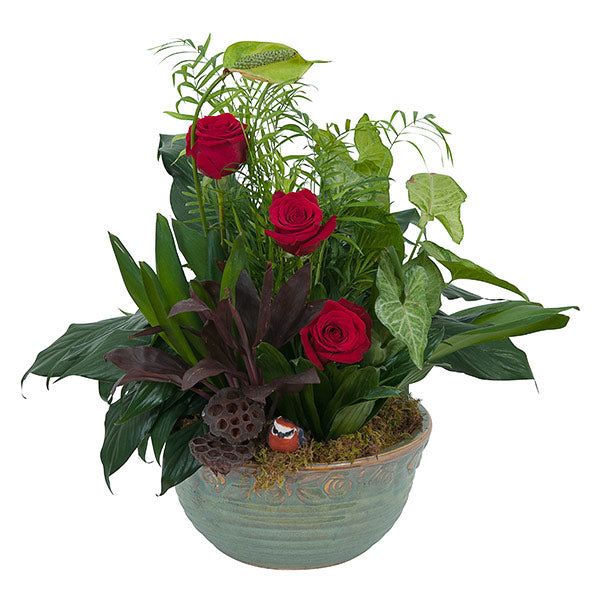 Beautiful arrangement featuring red roses and lush greenery in an elegant decorative pot. Perfect for any occasion.