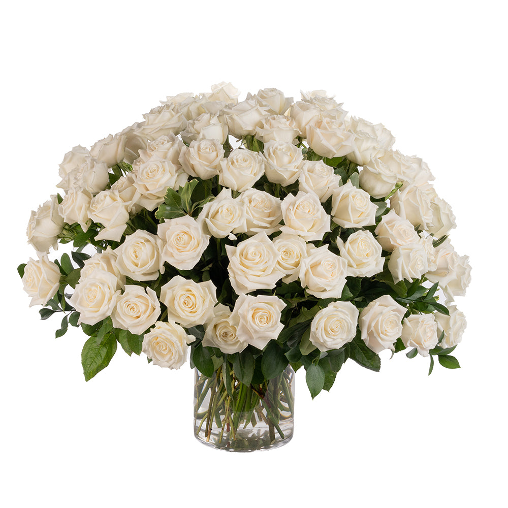 A lush arrangement of elegant white roses in a clear glass vase, perfect for any special occasion.